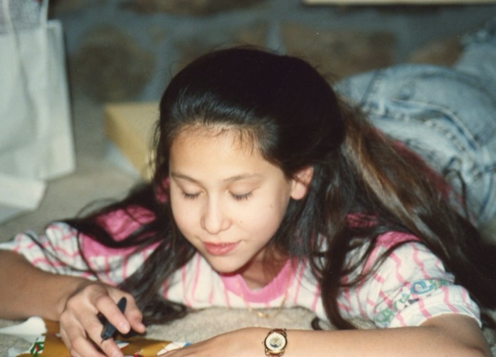 Amanda, seated by a window.